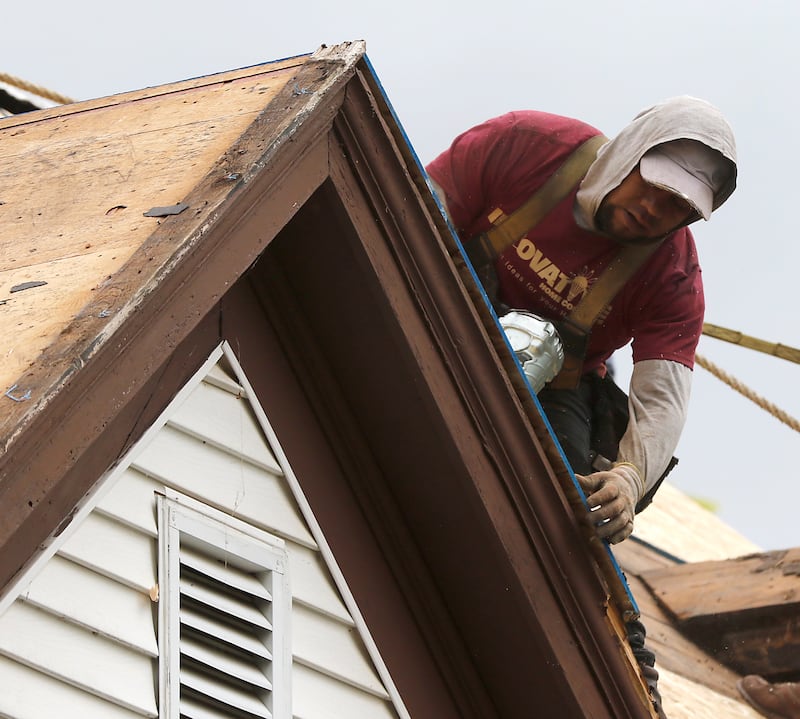 A worker from Innovative Home Concepts replace the roof on U.S Marine Corps veteran Mark McClaughry's home in McHenry on Thursday, May 22, 2025, as part of the “30 Days for 30 Vets” initiative. The project is a collaboration between The Bremer Team of Keller Williams Success and Innovative Home Concepts.