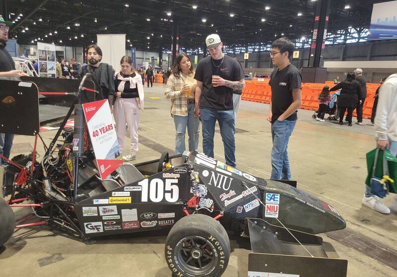 NIU Huskie Motorsports members Phillip Kim (right) and Abid Alnafoosi (left) speak to visitors at the team’s booth. Students explained their engineering decisions to both technical audiences and everyday car enthusiasts on Feb. 6, 2026.