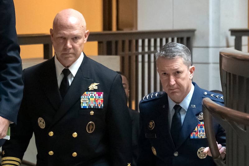 U.S. Navy Adm. Frank M. Bradley, accompanied by Gen. Dan Caine, chairman of the Joint Chiefs of Staff, right, walks to a meeting with senators on Capitol Hill, Thursday, Dec. 4, 2025, in Washington. (AP Photo/Mark Schiefelbein)