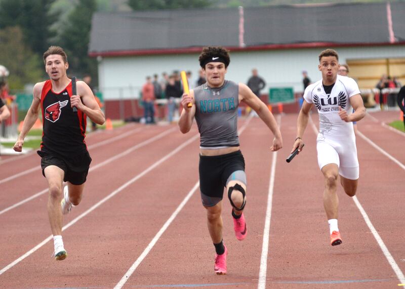 Forreston's Noah Dewey (left) chases Woodstock North's George Kingos (center) and Lena-Winslow's Jaylen Rakowska to the finish line in the 4x200 relay at the Hawk Classic on Friday, May 2, 2025 at Landers-Loomis Field in Oregon. Forreston finished second, 1:31.18 to Woodstock's 1:31.04.