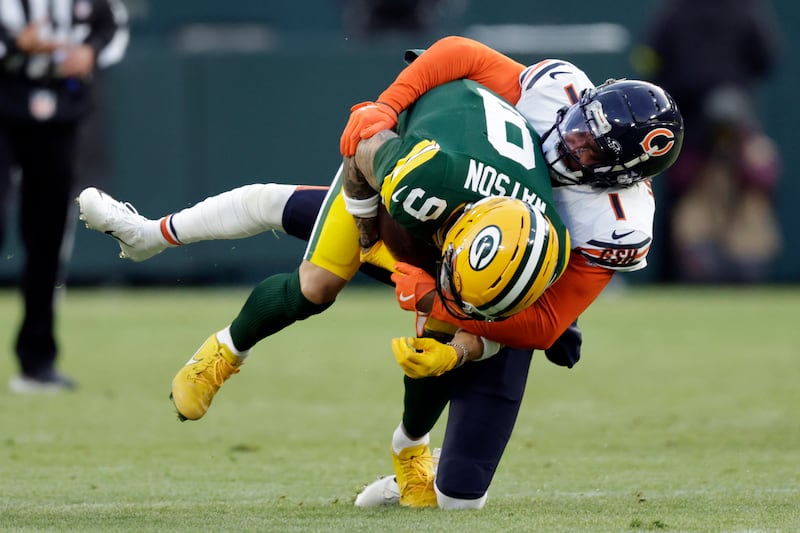 Chicago Bears cornerback Jaylon Johnson (1) tackles Green Bay Packers wide receiver Christian Watson (9) during the first half of an NFL football game Sunday, Dec. 7, 2025, in Green Bay, Wis. (AP Photo/Matt Ludtke)
