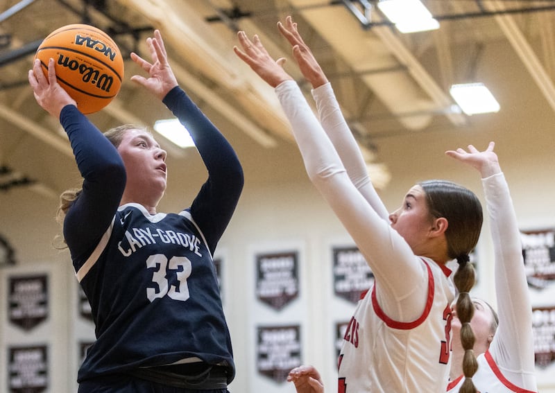 Cary-Grove High School forward Ellie Mjaanes, left, shoots the ball during a game against Huntley High School on Tuesday, Dec. 3, 2024.