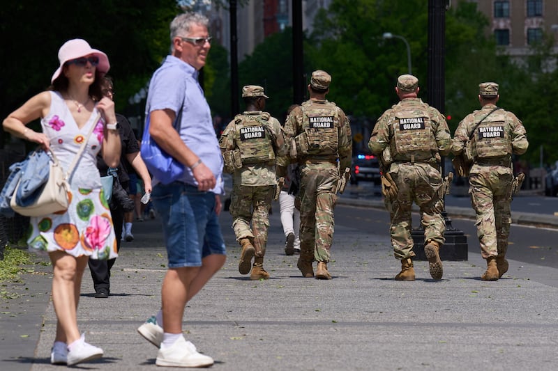 Members of the Florida National Guard pass by tourists on a sidewalk Friday April 17, 2026, in Washington. (AP Photo/Jacquelyn Martin)