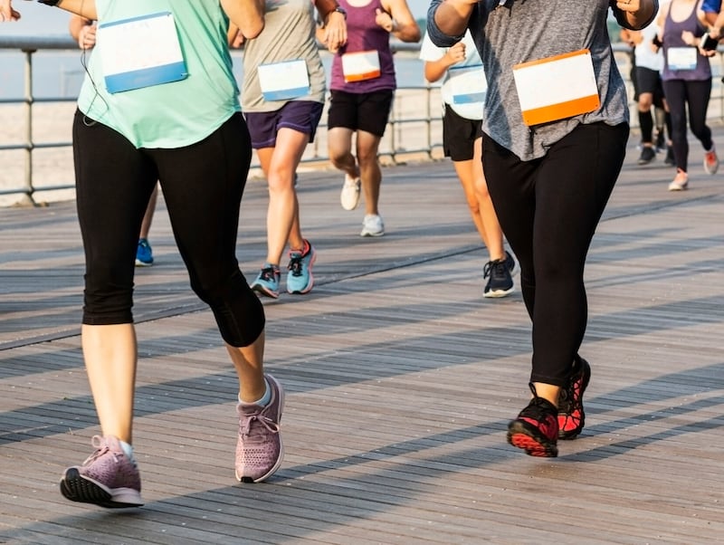 Runners from waist down on a boardwalk