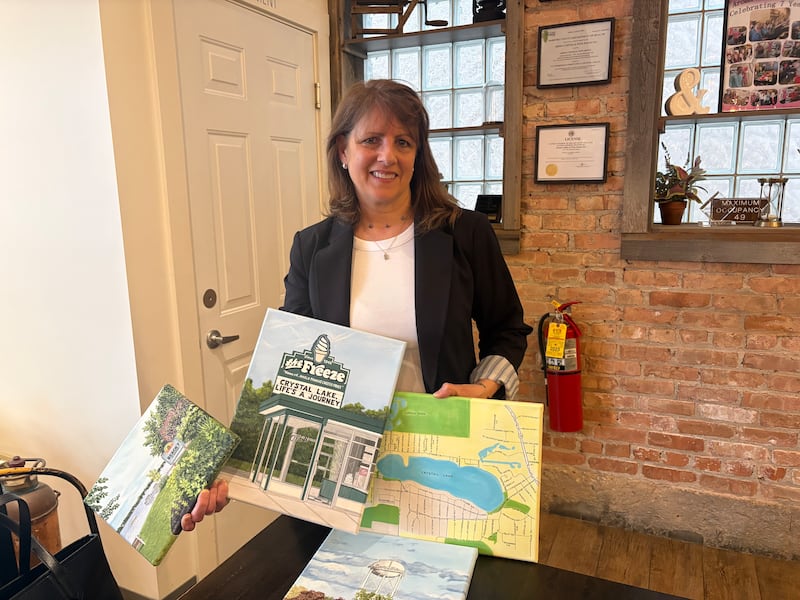 Lisa Mottola Hudon with some of her personal favorite paintings she created featuring Crystal Lake landmarks.