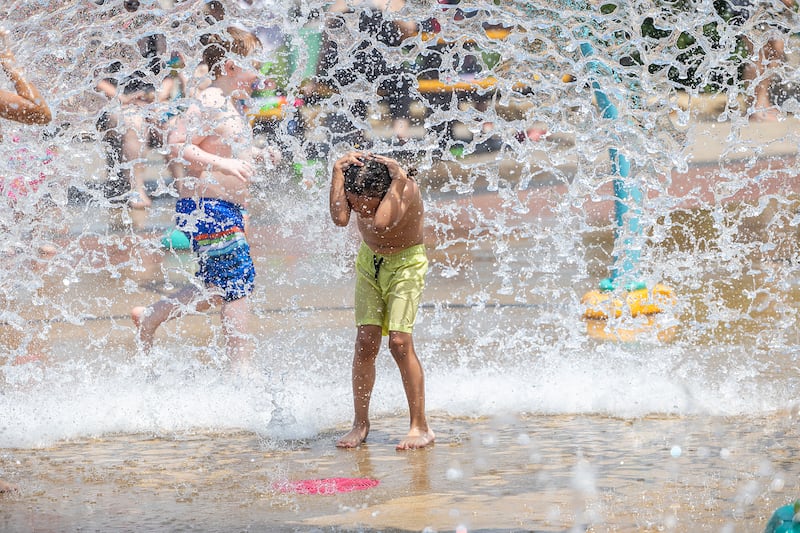 A youngster shields himself from a deluge of water Wednesday, June 11, 2025, at the Water Wonderland splash pad in Dixon. The hot weather brought all the boys and girls to the yard to fight the heat.