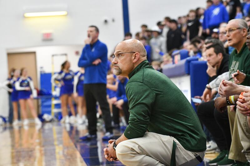 Bishop McNamara head coach Adrian Provost watches a free throw as Bismarck-Henning head coach Gary Tidwell does the same in the background during the Fightin' Irish's 52-49 loss in the IHSA Class 2A Peotone Sectional championship on Friday, March 7, 2025. The two head coaches were once teammates together at Olivet Nazarene University.