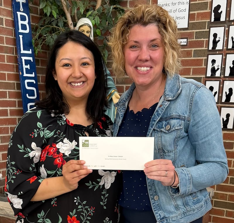 DeKalb County Community Foundation board member Lizy Garcia Ramirez (left) presenting a $7,1000 spring 2026 grant check to St. Mary School in DeKalb principal Ashley Davis