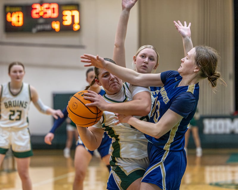 Hannah Waszkowiak (44) of St. Bede struggles to hold ball as Marquette's Emily Adair (13) attempts to strip it from her possession on Friday, January 16, 2026 at St. Bede Academy in Peru.