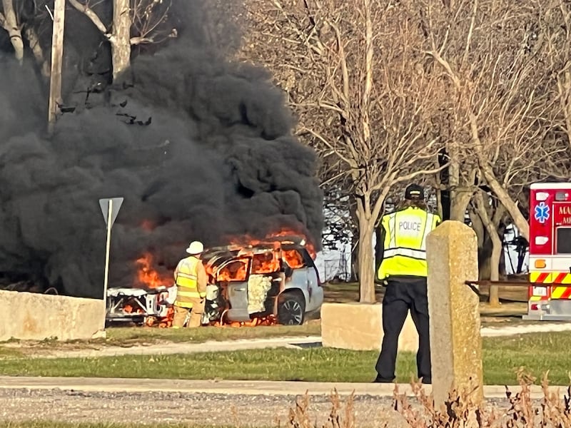 Plumes of black smoke rises through the air on Friday, Nov. 14, 2025, from a car fire near the parking lot of Sycamore Speedway. Authorities from the Kane County Sheriff's Office and Maple Park police were among those who responded.