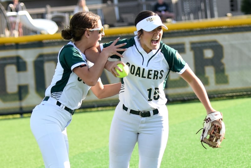Coal City's Juliana Covington, left, and Kaycee Graf celebrate after Graf caught the final out of the Coalers' 7-5 win over Bishop McNamara in the Class 2A Coal City Regional championship Friday, May 23, 2025.