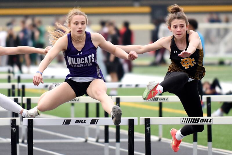Wilmington's McKenna Van Tilburg, left, and Reed-Custer's Alyssa Wollenzein clear the final hurdle during the 100 m hurdles at the Herscher Invite Friday, May 2, 2025.