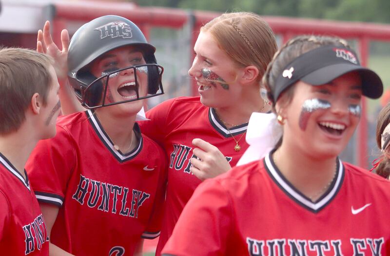 Huntley’s Ava McFadden, second from left, is greeted by the Red Raiders after belting a home run against DeKalb in IHSA Class 4A Sectional Semifinal softball action at Barrington High School in Barrington on Wednesday, June 4, 2025.