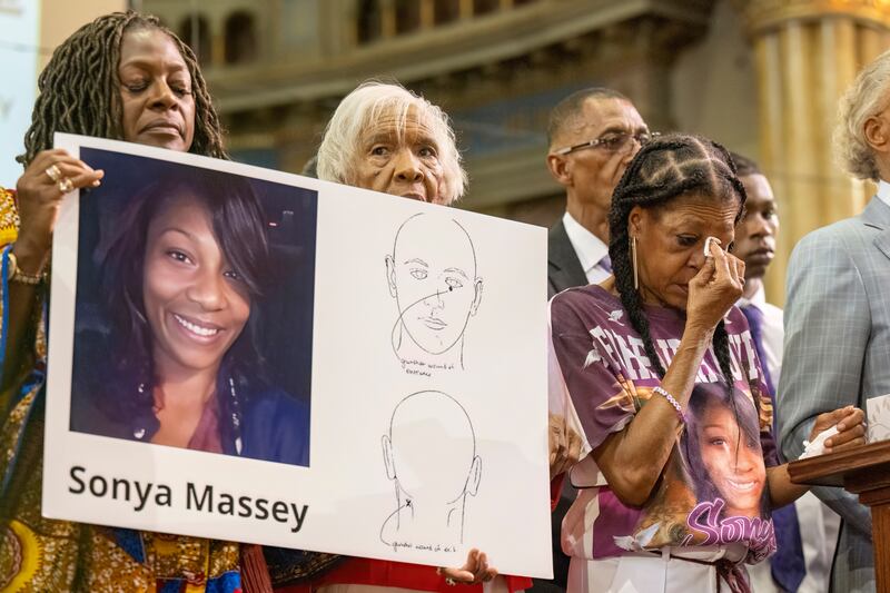 FILE - Donna Massey, center right, wipes tears from her face as she listens to Rev. Al Sharpton, right, speak during a press conference over the shooting death of her daughter Sonya, who was killed by Illinois sheriff's deputy Sean Grayson, at New Mount Pilgrim Church in the Garfield Park neighborhood in Chicago, Tuesday, July 30, 2024. (Tyler Pasciak LaRiviere/Chicago Sun-Times via AP, file)