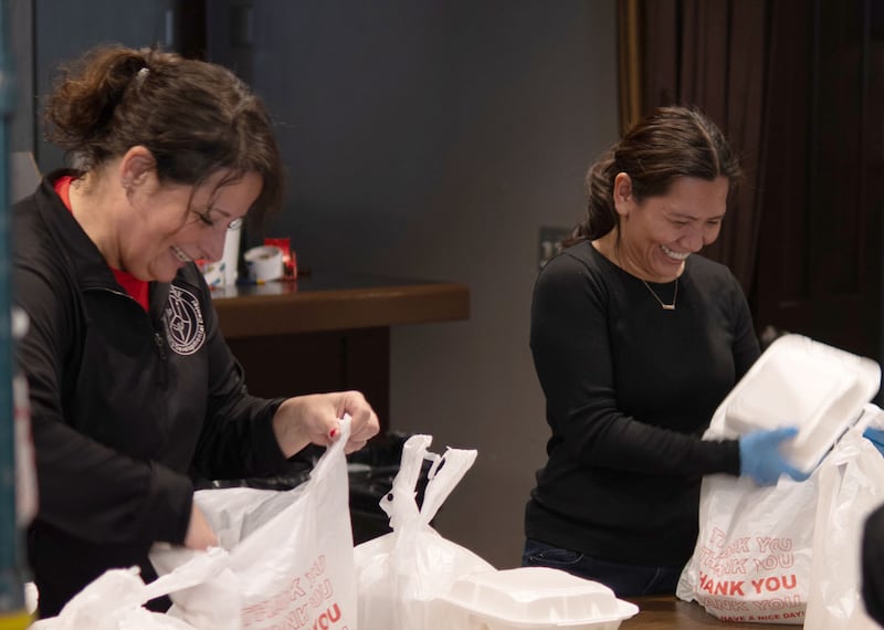Volunteers help pack dinners to cars during the Lighted Way Spaghetti Supper on Monday, April 22, 2024 at Uptown Bar and Grill in La Salle.