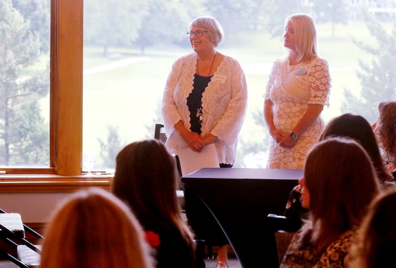 Award recipient Ellen Hanson stands with Northwest Herald publisher Laura Shaw as Kathleen Caldwell introduces Hanson during the Northwest Herald's Women of Distinction award luncheon Wednesday June 5, 2024, at Boulder Ridge Country Club, in Lake in the Hills. The luncheon recognized 11 women in the community as Women of Distinction.