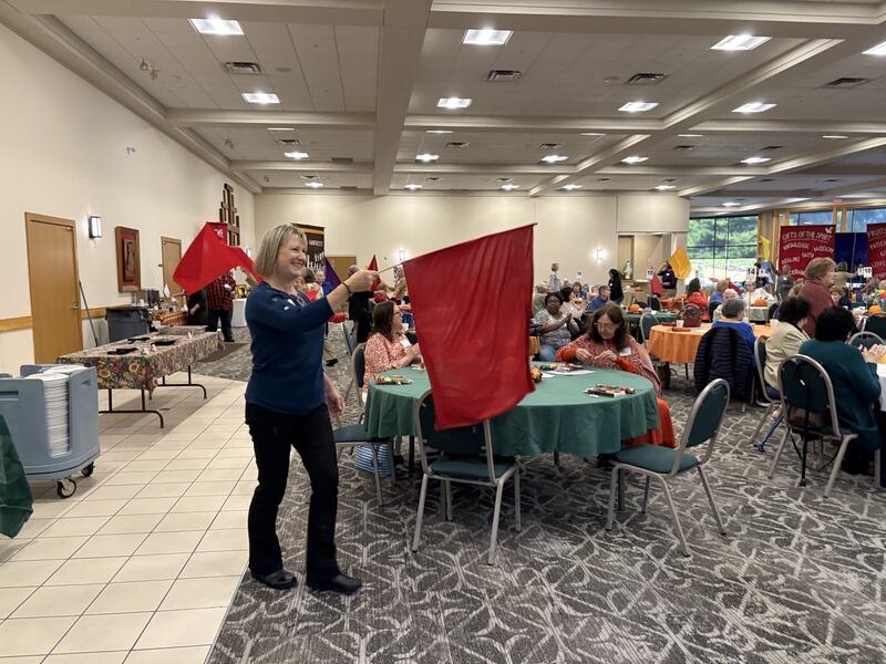 Stephanie Diedrich waves a flag during the Magnificat prayer breakfast in Crystal Lake Oct. 11, 2025.