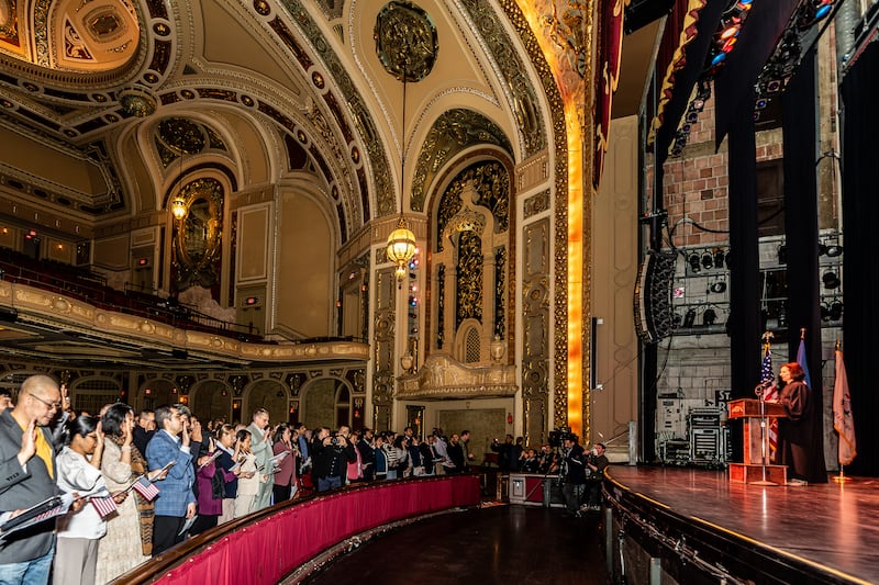 Honorable Laura K. McNally, U.S. District Court for the Northern District of Illinois, administers the Oath of Allegiance during the Naturalization Ceremony at Rialto Square Theatre in Joliet on April 17, 2025.