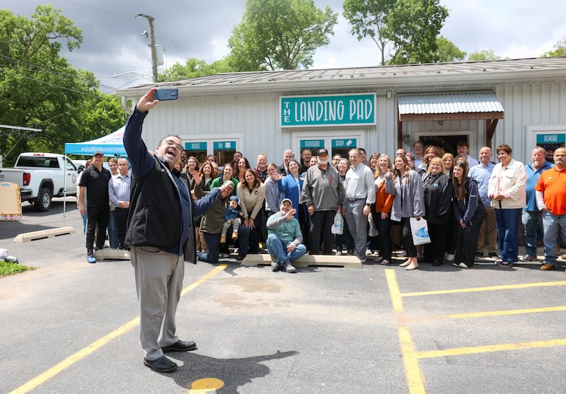 Robert Navarro, President and CEO of Heritage Corridor Destinations, takes a selfie with those in attendance for The Landing Pad Souvenir Shop's official ribbon-cutting ceremony at Wilmington's South Island Park on Thursday, May 22, 2025.
