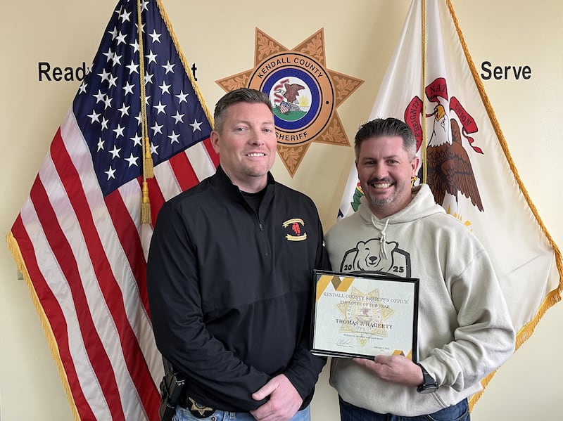 Kendall County Sheriff’s Sergeant Tom Hagerty, left, accepts the Kendall County Sheriff's Employee of the Year certificate from Kendall County Undersheriff Bobby Richardson, right.