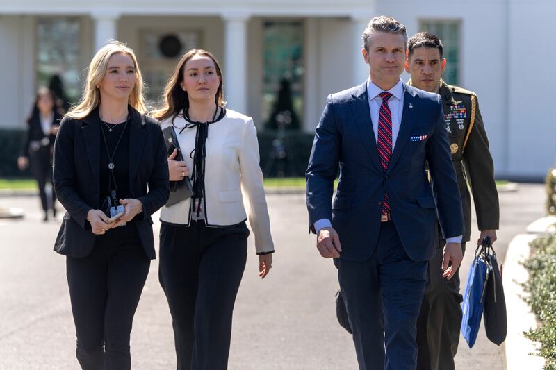 Defense Secretary Pete Hegseth, second from right, walks outside the Oval Office at the White House, Friday, March 21, 2025, in Washington. (AP Photo/Mark Schiefelbein)