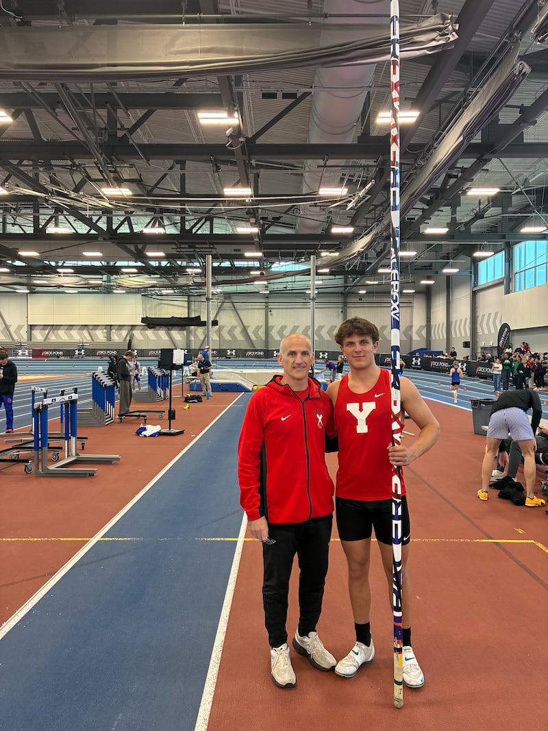 Ben Niles (left), shown here with Yorkville's Evan Fals, is a volunteer assistant track and field coach specializing in pole vault. Niles also teaches at Oswego East High School.