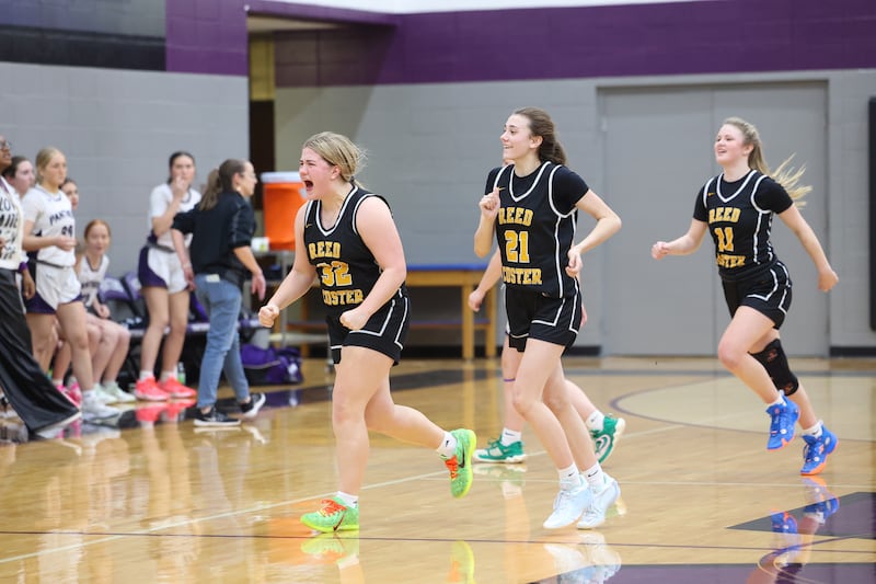 Reed-Custer's Harlie Liebermann yells in celebration alongside teammates Alyssa Wollenzien, center, and Morgan Toler, right, as the Comets secured a 45-42 upset victory over Manteno on Monday, Feb. 2, 2026.