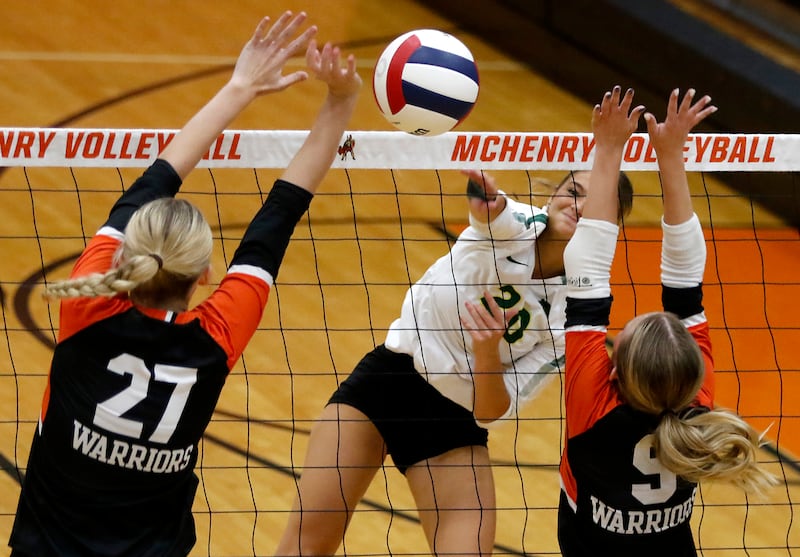 Crystal Lake South's Bobbi Wire hits the ball between the block attempt of McHenry's Lily Ahrens (left) and McHenry's Stella Murch (right) during a Fox Valley Conference volleyball match on Thursday, Aug. 28, 2025, at the Freshman Campus of McHenry High School in McHenry.