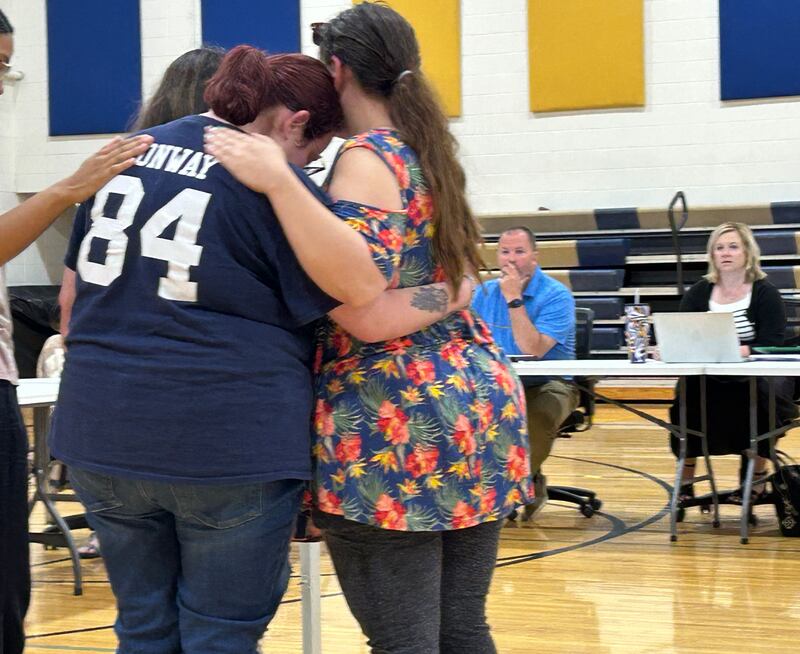 Friends of Joshua Conway comfort his sister, Jessica, after she addressed the Polo School Board during the public comment period at the board's regular meeting on Wednesday, June 18, 2025 at the Centennial Grade School. Also pictured are  Polo School Board President Matt Mekeel and Superintendent Kelley Mandrell.