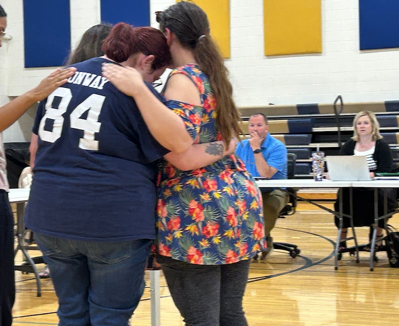 Friends of Joshua Conway comfort his sister, Jessica, after she addressed the Polo School Board during the public comment period at the board's regular meeting on Wednesday, June 18, 2025 at the Centennial Grade School. Also pictured are Polo School Board President Matt Mekeel and Superintendent Kelley Mandrell.