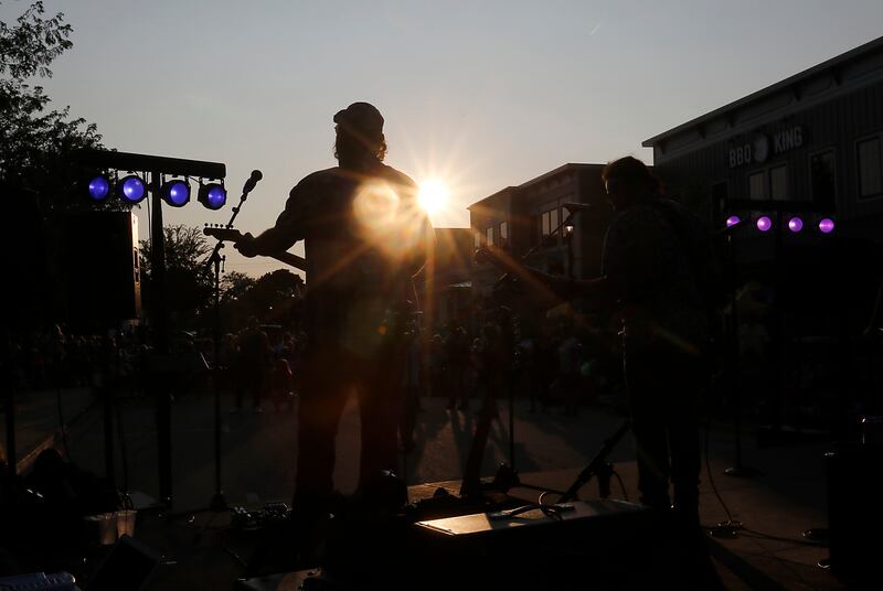 Mike Aquino of One of These Nights, an Eagles tribute band, plays the guitar as the sun set Tuesday, Aug. 8, 2023 during Huntley’s weekly Concert on the Square.