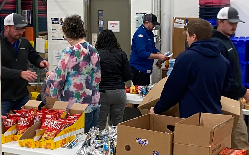 United Way of Grundy County's Morris Herald Angels Campaign 2024. Photo of volunteers sorting food and stocking shelves at We Care of Grundy County