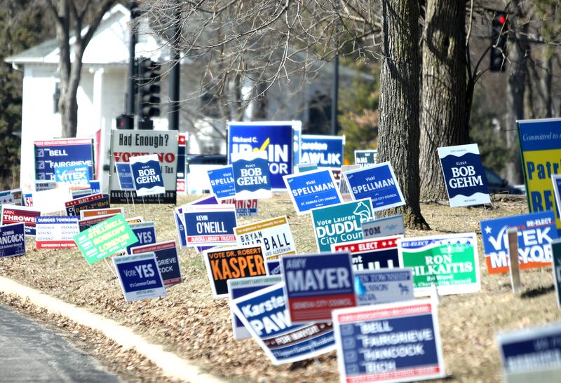 Campaign signs for the 2025 Consolidated Election line the roadway near the Kane County Government Center.