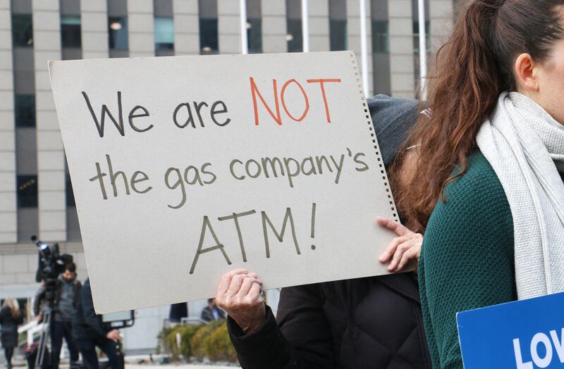 A demonstrator holds a sign reading, “We are NOT the gas company’s ATM!” at a protest held by consumer, environmental and community activists on Jan. 6, 2026. The group was criticizing Peoples Gas’ filing that sought to raise gas delivery rates in 2027.