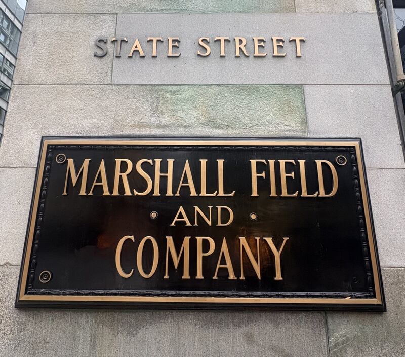 A Marshall Field and Company brass plaque hangs on the department store's original State Street building. Though the business has been bought by Macy's the building has landmark status and will always be known to as the Marshall Field's building.