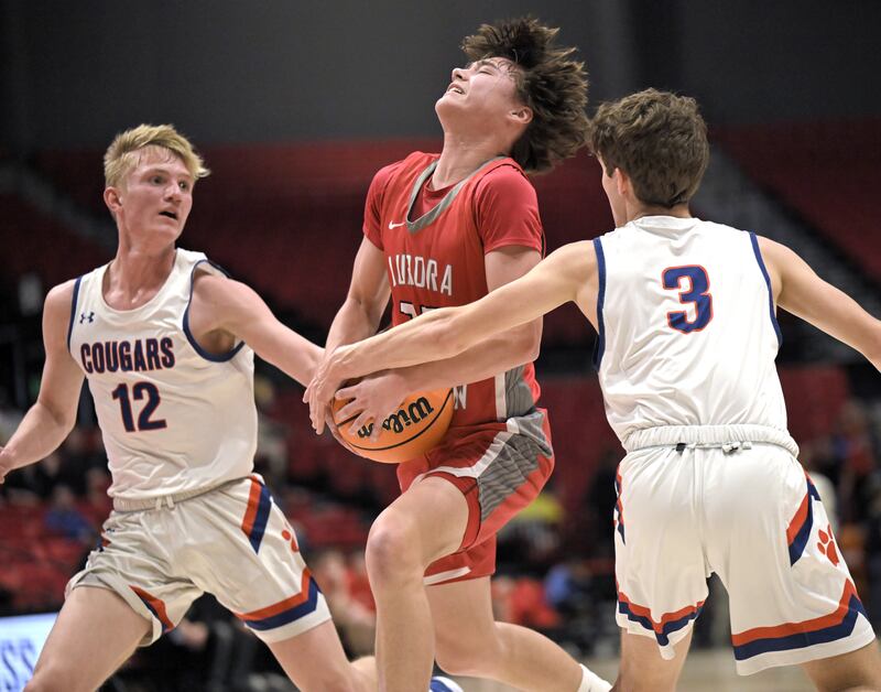 Aurora Christian’s Jacob Baumann tries to draw a fould as he drives between Eastland’s Adam Awender and Tanner Stern, right, in a IHSA Class 1A boys basketball supersectional at Northern Illinois University in DeKalb on Monday, Mar. 10, 2025.