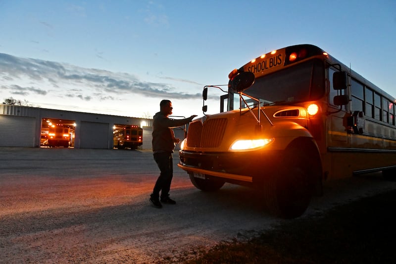A Herscher School District bus driver completes a safety check as they prepare for a morning route in November 2022.