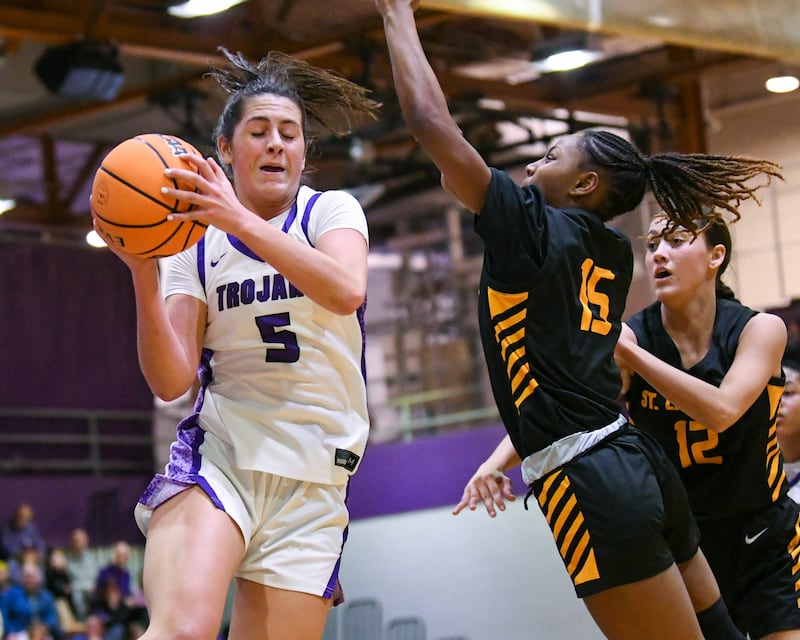 Downers Grove North's Campbell Thulin (5) gets a rebound during the 4A regional championship game on Thursday Feb. 19, 2026, while being defended by St. Laurence's McKenzie Saffold (15) held at Downers Grove North High School.