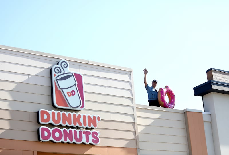 St. Charles Police Community Service Officer Francisco Fregoso waves from the roof during the 2024 Cop on a Rooftop fundraiser for Special Olympics Illinois at the Dunkin’ Donuts at 1566 E. Main St. in St. Charles on Friday, May 17, 2024.