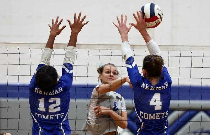 Princeton senior Keighley Davis hits through Newman's Gisselle Martin (12) and Ruby Burger (4) Tuesday at Prouty Gym. The Tigresses won 2-0.