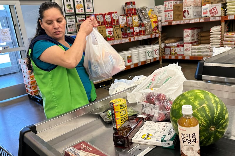 An employee works at a cash register in a grocery store in Schaumburg, Ill., Thursday, Sept. 18, 2025. (AP Photo/Nam Y. Huh)