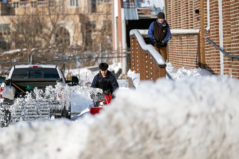 Isaac Kendrick (left) and Carson Leigh work to clear the sidewalk of Mad Water Saloon Sunday, Nov. 30, 2025, in Dixon.