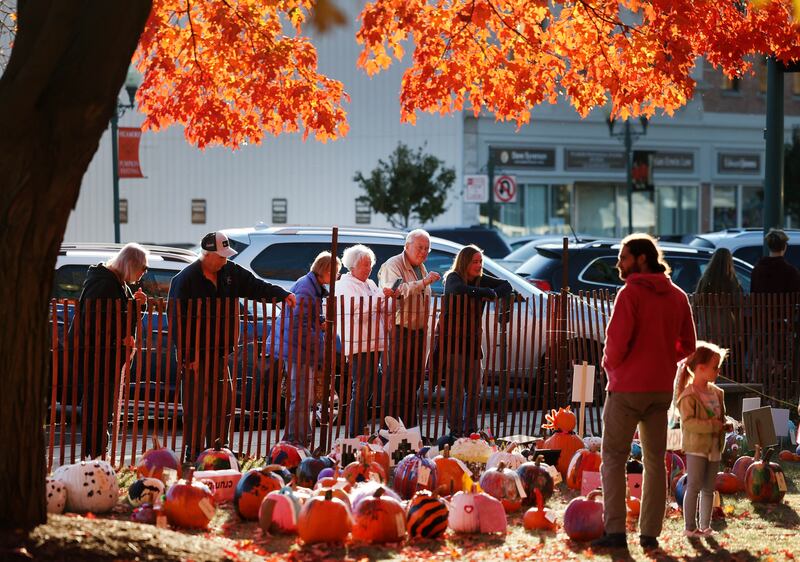 Visitors check out some of the entries into the pumpkin contest Wednesday, Oct. 23, 2024, on the DeKalb County Courthouse lawn during the Sycamore Pumpkin Festival.