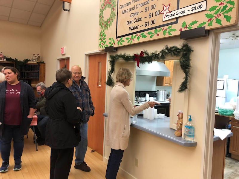 Attendees of the German Christkindlmarket in Princeton line up to taste authentic German food, including bratwurst and sauerkraut on Saturday, Nov. 19, 2022 at Open Prairie United Church of Christ.