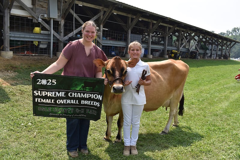 Brenna Noon (left) presents the banner to Lyla Rittmeyer for Supreme Champion Female in the Dairy show. This banner was sponsored in memory of Brenna’s grandfather, Arnold Noon.