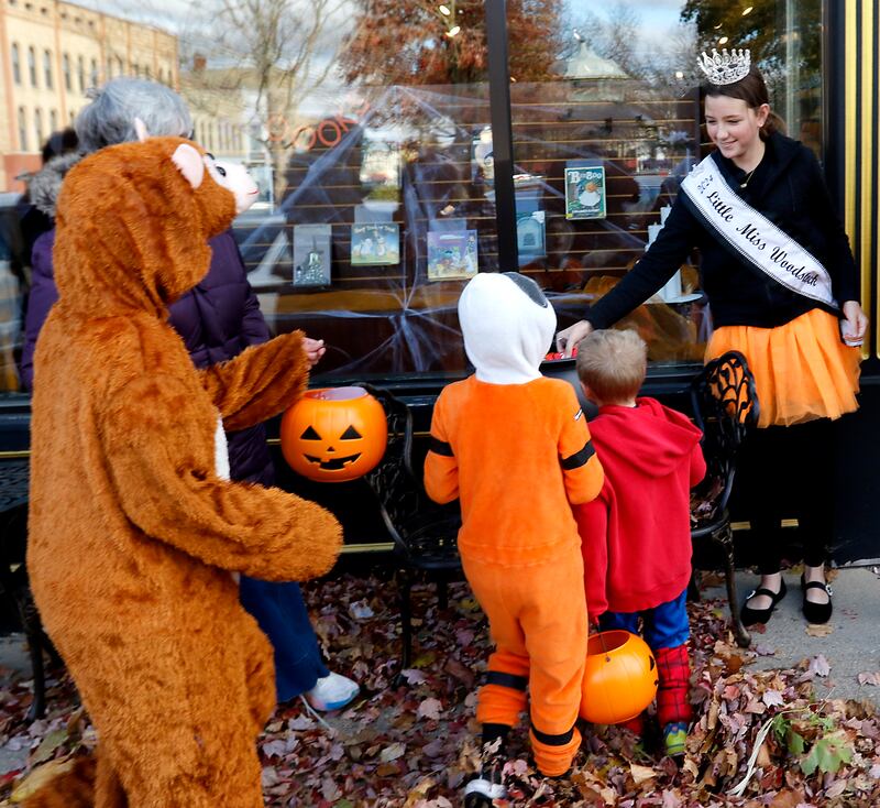 Gia Galli, the 2024 Little Miss Woodstock, hands out candy to trick or treaters during Halloween on the Square on Thursday, Oct. 31, 2024, in Woodstock. The event featured trick and treating and a costume contest.