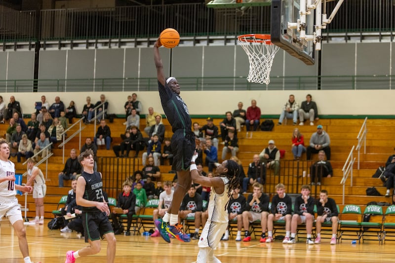 Glenbard West's Josh Abushanab goes in for the shoot over Yorkville's Alonn Flint on Friday Dec. 26,2025 at the 51st. Annual Jack Tosh Holiday Tournament in Elmhurst.