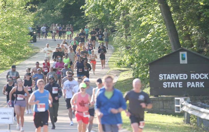 Hundreds of runners pass by the entrance to Starved Rock State Park while competing in the Starved Rock Country half-marathon on Saturday, May 10, 2025 at Starved Rock State Park.
