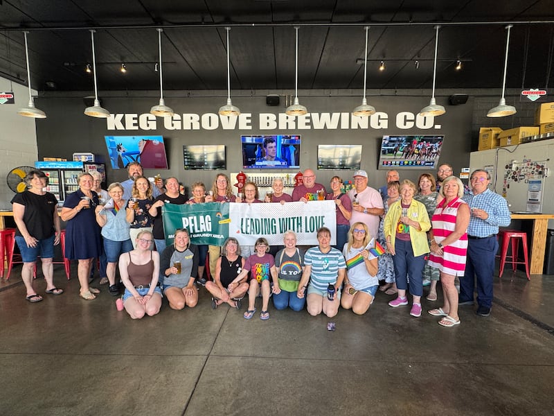 Caption: PFLAG Morris / Grundy Area celebrated one year of supporting LGBTQ+ families. In place of a chamber ribbon cutting, PFLAG members, chamber representatives, and city officials had a toast at Keg Grove Brewing in conjunction with the launch of their "Love is Love" Brew.