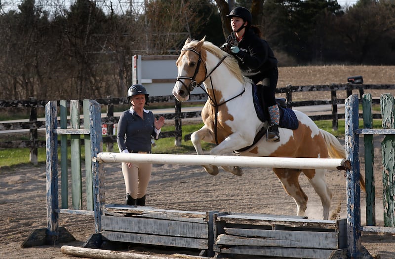 Teacher Amber Bauman works with Violet Capra and Capra's horse, Angel, on Wednesday, April 16, 2025, during a horseback riding lesson at Valley View Acres near Woodstock. Bauman, also teaches 6th grade math at Hannah Beardsley Middle School in Crystal Lake.
